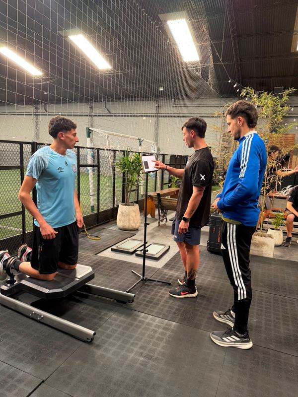 Entrenador realizando una evaluación de fuerza a un deportista